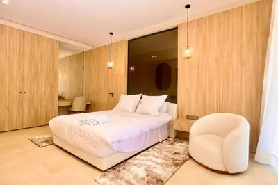 a bedroom with a white bed and a chair at Villa youngLA in Sehib Foukani