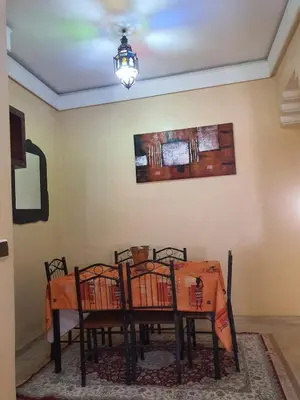 a dining room table with chairs and a chandelier at Appartememt Hivernage 4 in Marrakech