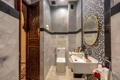 a bathroom with a sink and a toilet and a mirror at Riad Musee in Marrakech