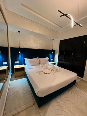 a bedroom with a large white bed with blue lights at Studio Rolex Guéliz, situé à seulement 5 minutes de la place Jemaa El-Fna in Marrakech