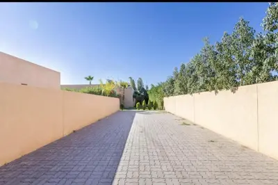 a brick sidewalk next to a wall and trees at Villa Atlas piscine chauffee sans vis a vis in Marrakech