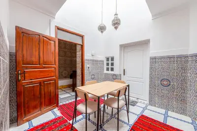 a dining room with a wooden table and chairs at Dar Tbib in Marrakech