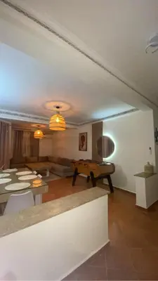 a living room with a couch and a table at Appartement Marrakech gueliz climatisé avec piscine et baby foot in Marrakech