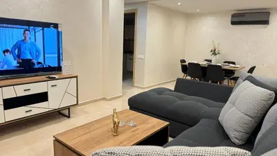 a living room with a couch and a flat screen tv at Honey home Marrakech in Marrakech