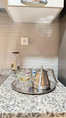 a silver tea kettle and glasses on a counter at Honey home Marrakech in Marrakech