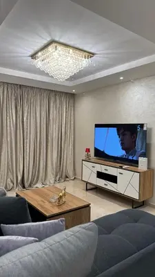 a living room with a large television and a couch at Honey home Marrakech in Marrakech