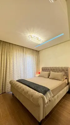 a bedroom with a large bed with a blue light on the ceiling at Honey home Marrakech in Marrakech