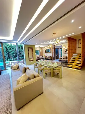 a living room with a couch and a table at Villa Elixir , Luxury residence , private pool in El Rhechat
