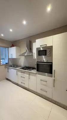 a kitchen with white cabinets and a stove top oven at Prestigia Pool 5 min Airport in Marrakech