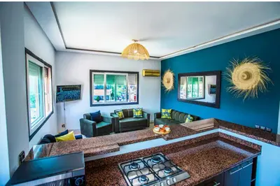 a living room with a kitchen with blue walls at Appartement moderne Guéliz, Centre Marrakech in Marrakech