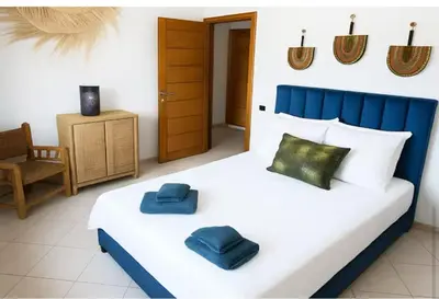 a bedroom with a bed with two blue pillows on it at Appartement moderne Guéliz, Centre Marrakech in Marrakech