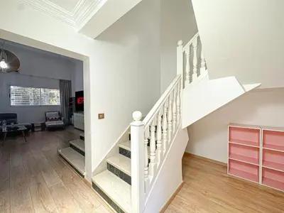a white staircase in a living room with wood floors at Duplex Majorelle avec Jardin et Parking in Marrakech
