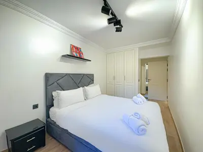 a bedroom with a white bed with towels on it at Duplex Majorelle avec Jardin et Parking in Marrakech