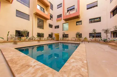 a swimming pool in front of a building at Chic & comfort in the heart of Marrakech train station in Marrakech