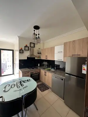 a kitchen with a table and a refrigerator at Amazing well located appartement centre of marrakech near medina in Marrakech