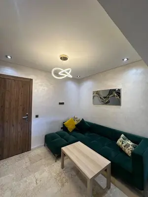 a living room with a green couch and a table at Amazing well located appartement centre of marrakech near medina in Marrakech