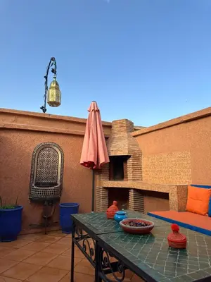 a patio with a table and an umbrella at Riad Medina Palmeraie in Marrakech