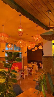 a restaurant with tables and chairs and chandeliers at Riad Medina Palmeraie in Marrakech