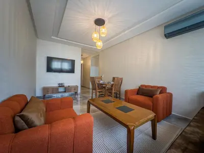 a living room with orange furniture and a table at Modern & cozy 2 bedroom apartment in Marrakech