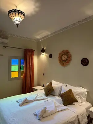 a bedroom with a large bed with white sheets at Riad Le Bijou de Zahra Marrakech Kasbah in Marrakech