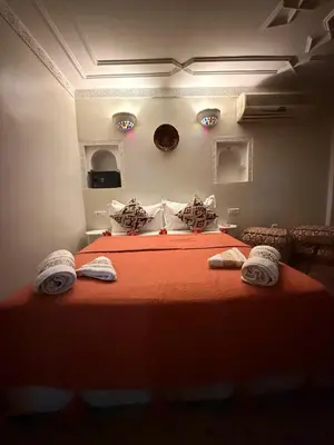 a bedroom with a bed with orange sheets and towels at Riad Le Bijou de Zahra Marrakech Kasbah in Marrakech