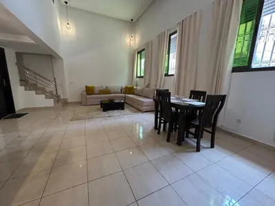 a living room with a table and chairs and a couch at Appartements du luxe in Marrakech
