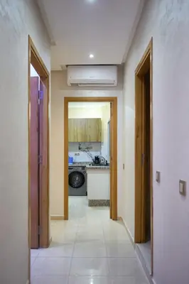 a hallway leading to a kitchen with a kitchenasteryasteryasteryasteryasteryasteryastery at Appartement l'aéroport in Marrakech