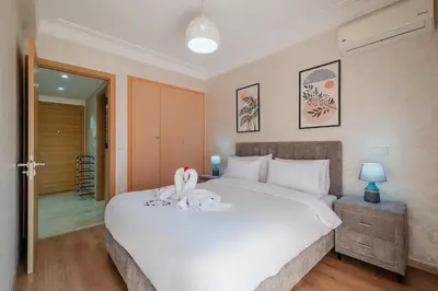 a bedroom with a white bed with a towel on it at Comfort, ideal location in Guéliz Marrakech in Oulad Akkou