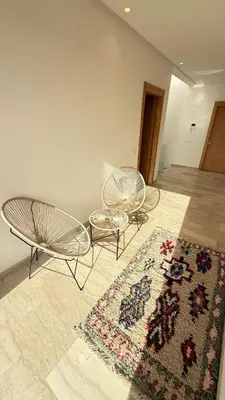 a living room with two chairs and a rug at Villa luxueuse in Marrakech