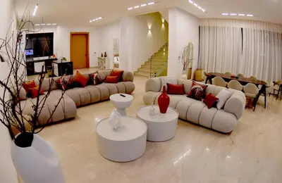 a living room with couches and tables and a staircase at Villa luxueuse in Marrakech