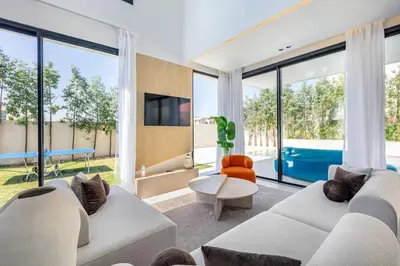 a living room with white furniture and large windows at Luxury Villa, Design, Comfort, Heated Pool, Games in Marrakech