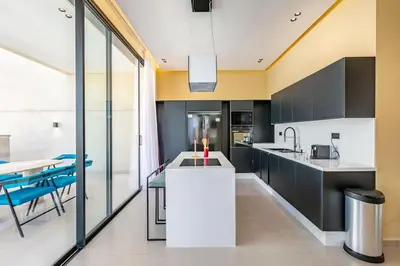 a kitchen with black and white cabinets and a table at Luxury Villa, Design, Comfort, Heated Pool, Games in Marrakech