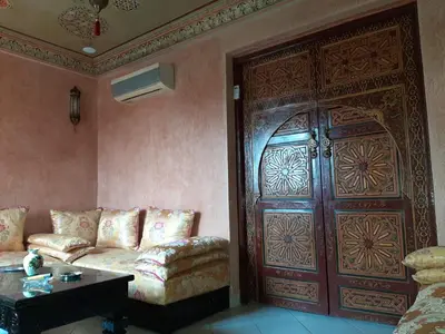 a living room with a couch and a large wooden door at Appartement centre de Marrakech in Marrakech
