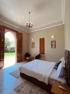a bedroom with a large bed and an open door at Villa Dar Zitoune in Marrakech