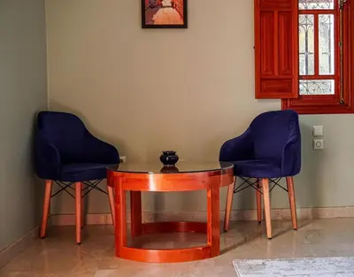 two blue chairs and a table in a room at Villa Dar Zitoune in Marrakech