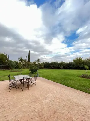 a picnic table and chairs in a park at Villa Dar Zitoune in Marrakech