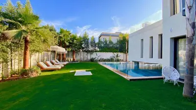 a yard with a pool and green grass at Villa de Rêve sans vis-à-vis à Marrakech in Marrakech
