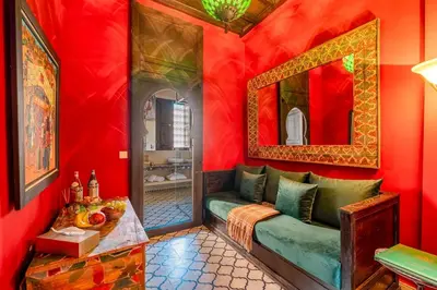a red room with a couch and a mirror at Riad Royal Koubba in Marrakech