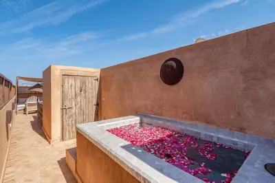a tub filled with pink flowers on a patio at Riad Royal Koubba in Marrakech