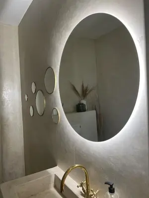 a bathroom with a round mirror over a sink at Riad Manoury Marrakech - privates Boutique-Hotel für 6 in Marrakech