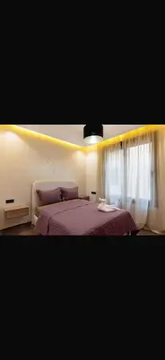 a bedroom with a bed with purple sheets and curtains at Moderne appart Gueliz 3 ch parking Carrefour in Marrakech