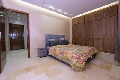 a bedroom with a bed and a large closet at Appartement calme avec piscine et parking in Marrakech