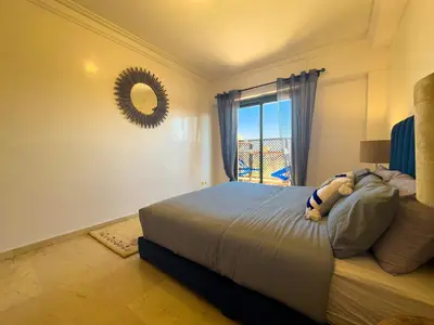 a bedroom with a bed with a mirror and a window at Gueliz 2-BR Apt Pool, Close to Majorelle Garden in Marrakech