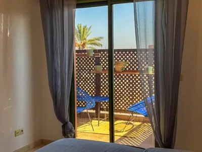 a bedroom with a balcony with a view of a patio at Gueliz 2-BR Apt Pool, Close to Majorelle Garden in Marrakech