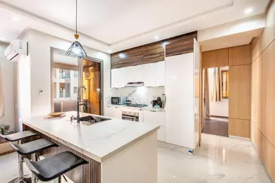 a kitchen with white cabinets and a large island at comfortable equipped apartment in Marrakech