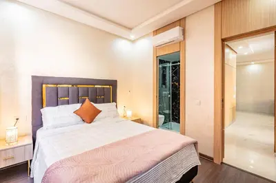 a bedroom with a large bed and a walk in shower at comfortable equipped apartment in Marrakech