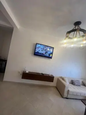 a living room with a couch and a tv on the wall at Appartement Marrakech in Marrakech