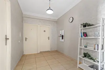a hallway with a white door and a clock on the wall at Massira Social Living in Marrakech