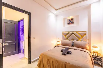 a bedroom with a large bed and a large mirror at Cosy appartement bed 1 in Marrakech