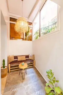 a living room with a bench and a chandelier at Cosy appartement bed 1 in Marrakech